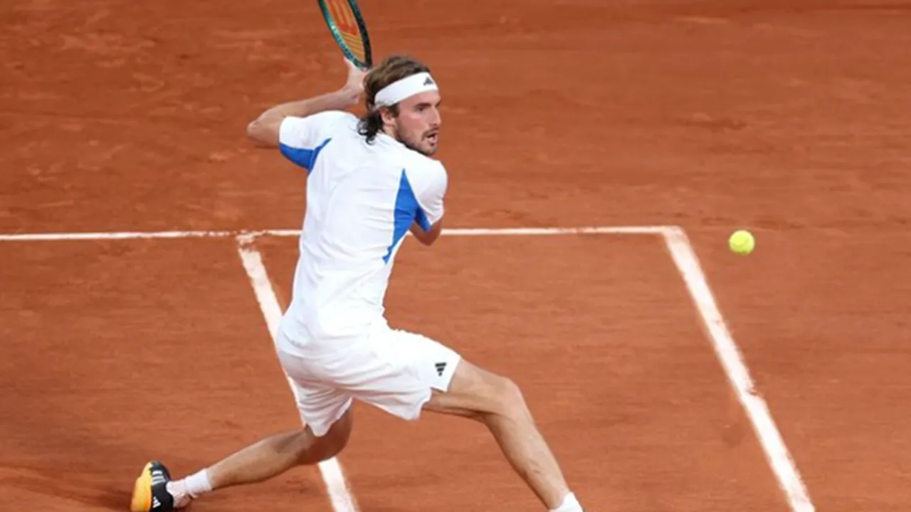 Stefanos Tsitsipas ejecutando un revés durante un partido en tierra batida.